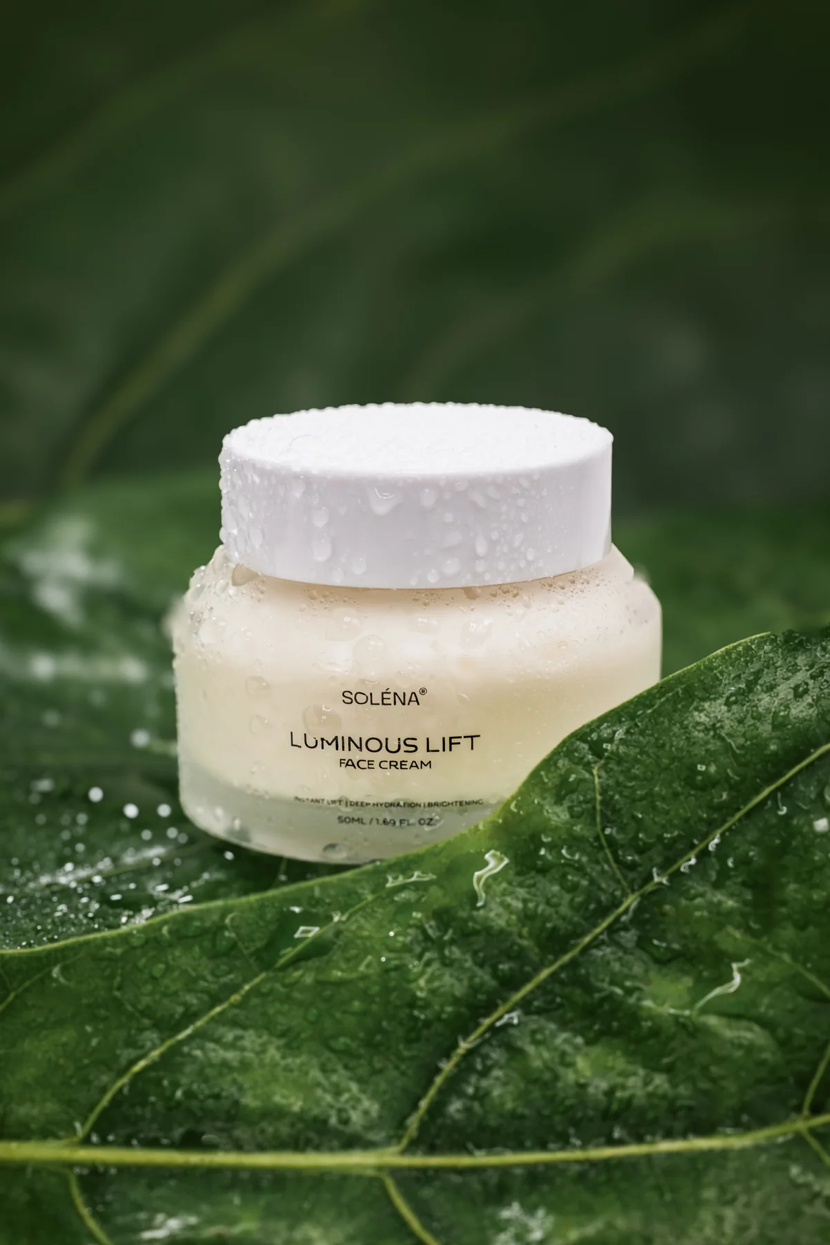 SOLÉNA Luminous Lift Face Cream jar among green leaves